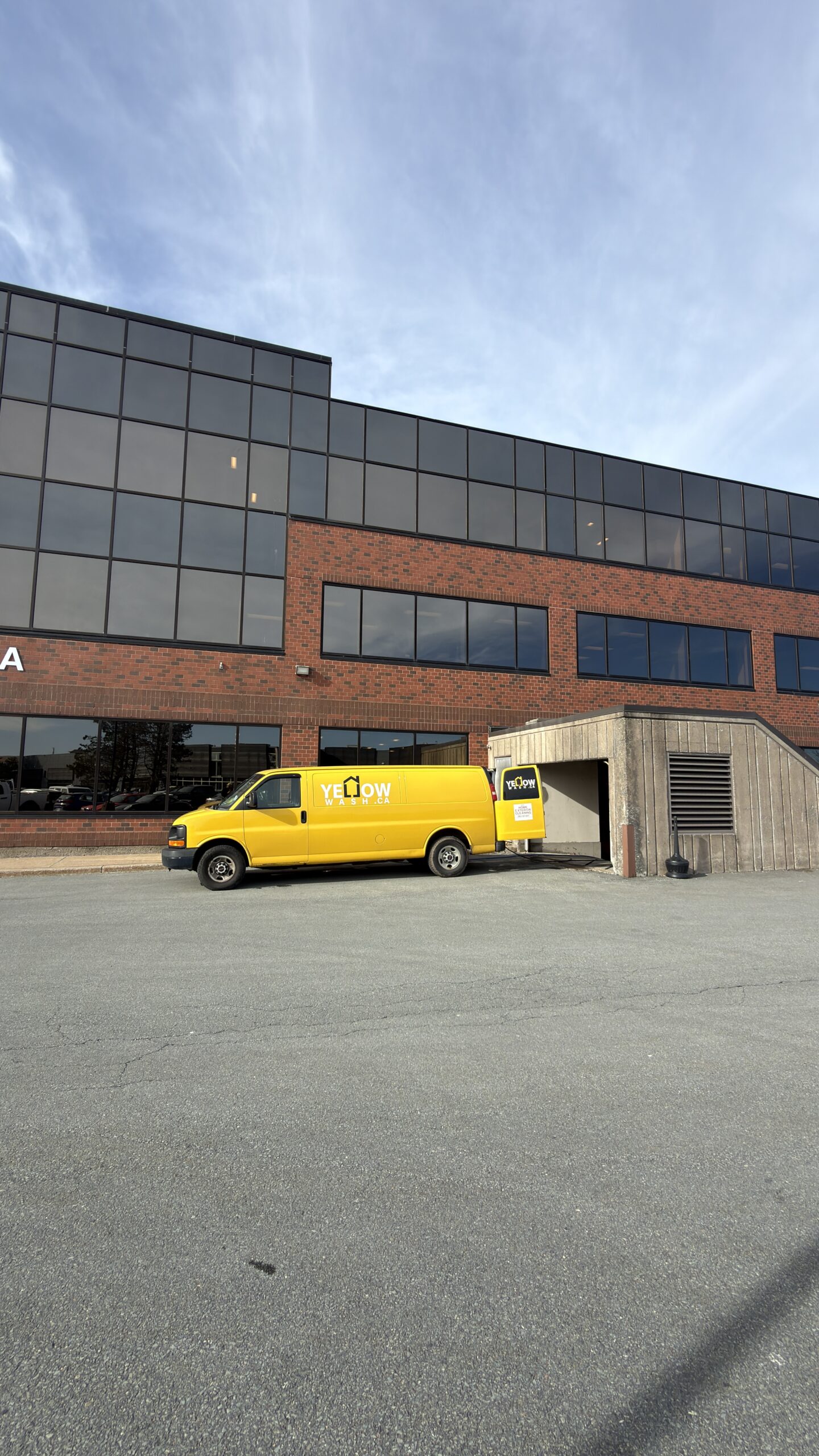 Yellow Wash van beside a commercial building