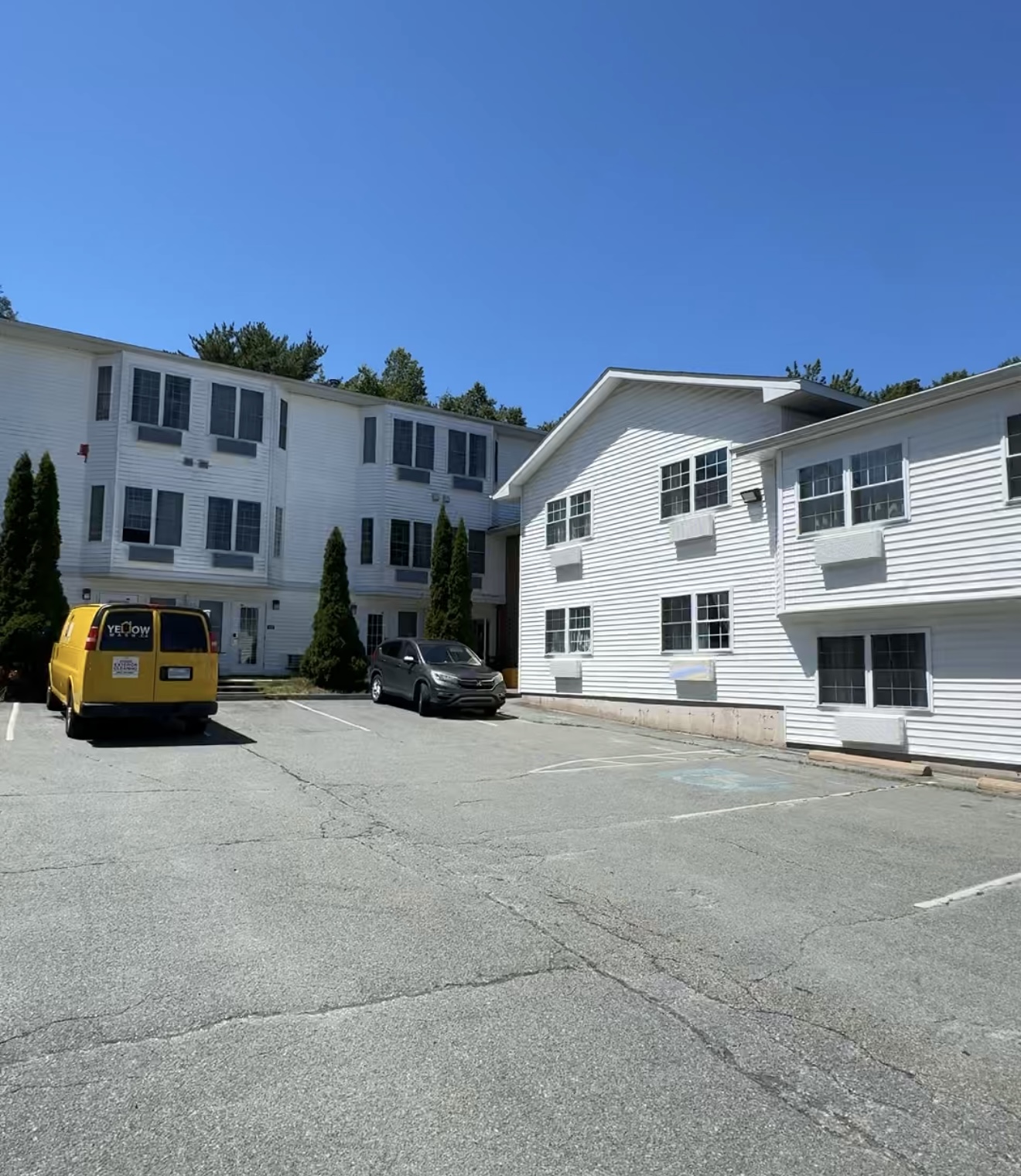 Hotel courtyard and white siding with a Yellow Wash van
