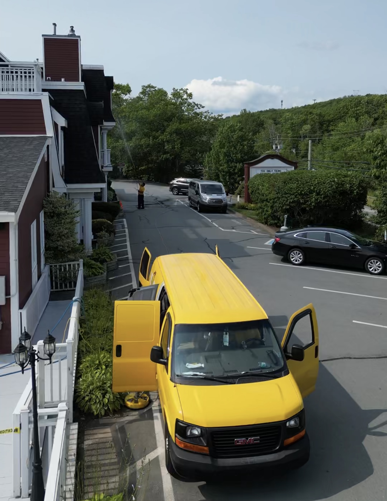 Yellow Wash van and technician working alongside a hotel